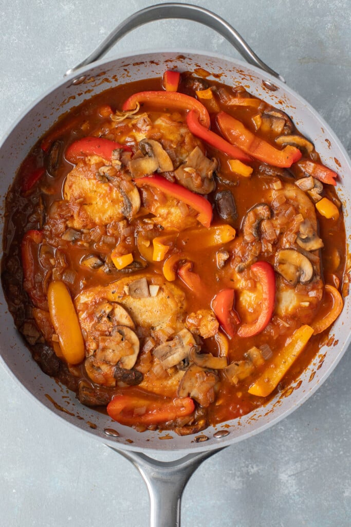 Chicken Stock and tomatoes added to a pan of veggies for chicken cacciatore