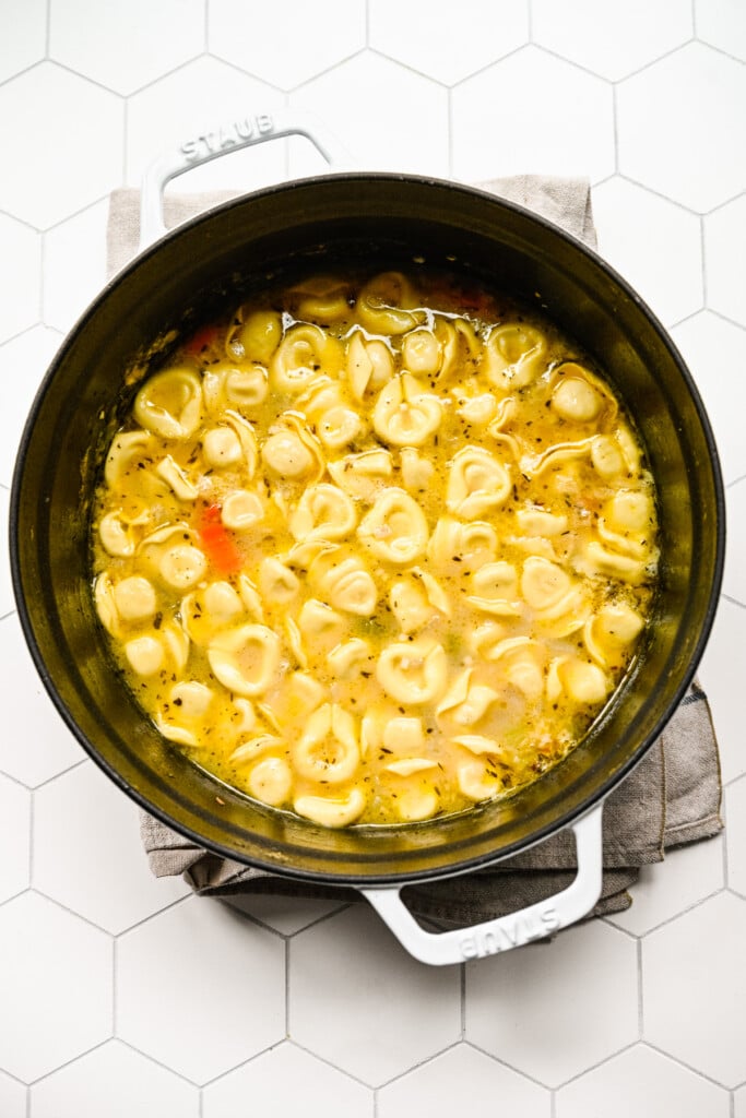 Tortellini added to a pot of sauteed veggies and chicken in broth to make chicken tortellini soup