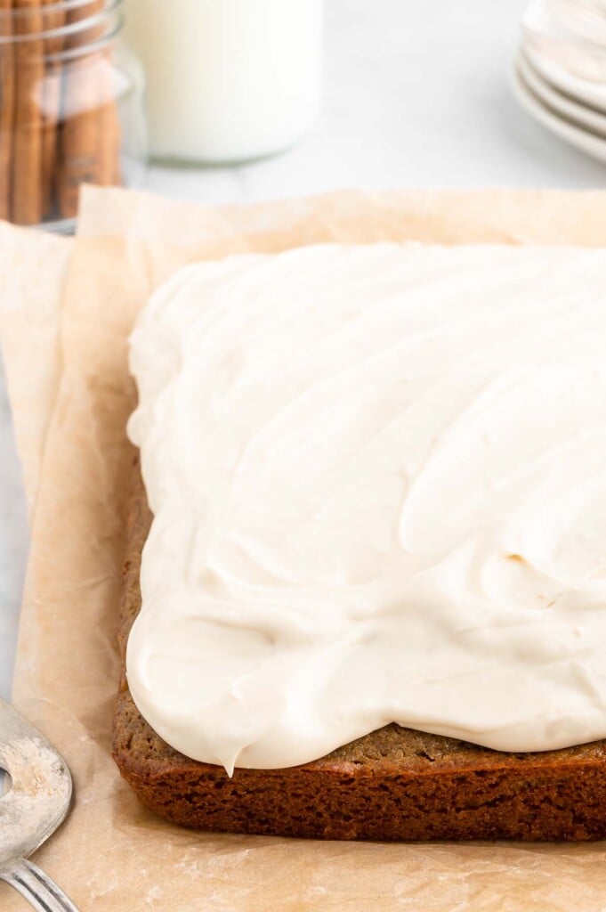 A healthy carrot cake with healthy cream cheese frosting on a parchment paper