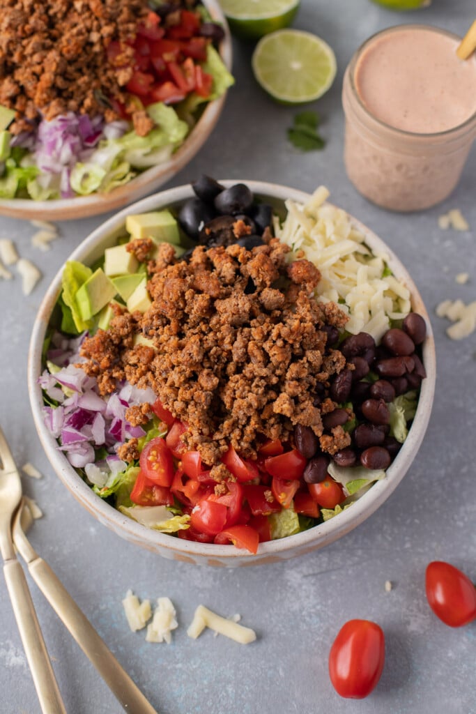 a close up of taco salad with lots of toppings assembled with no dressing