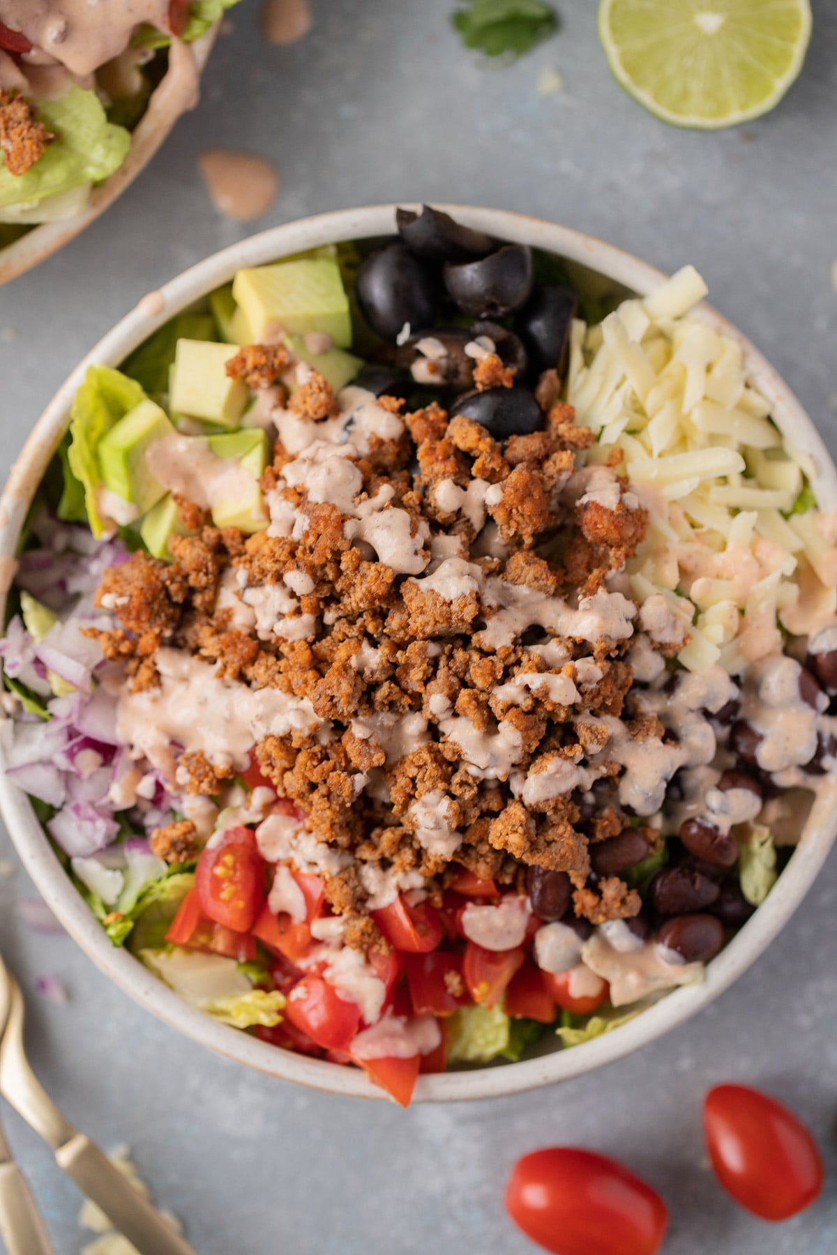 A close up overhead shot of healthy taco salad in a white salad bowl.