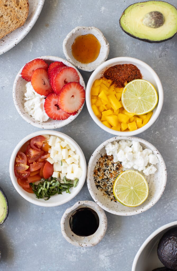 Small white bowls with toppings for avocado toast 