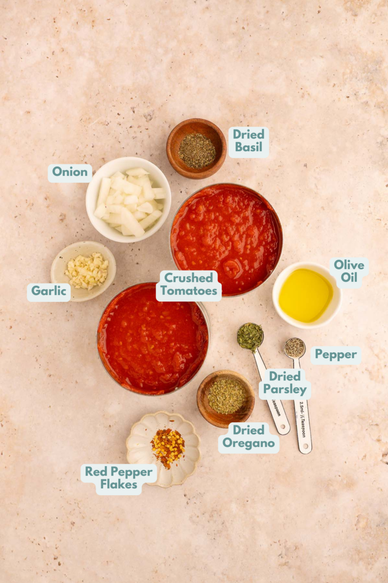 Labelled ingredients to make crockpot tomato sauce in small bowls and measuring cups.