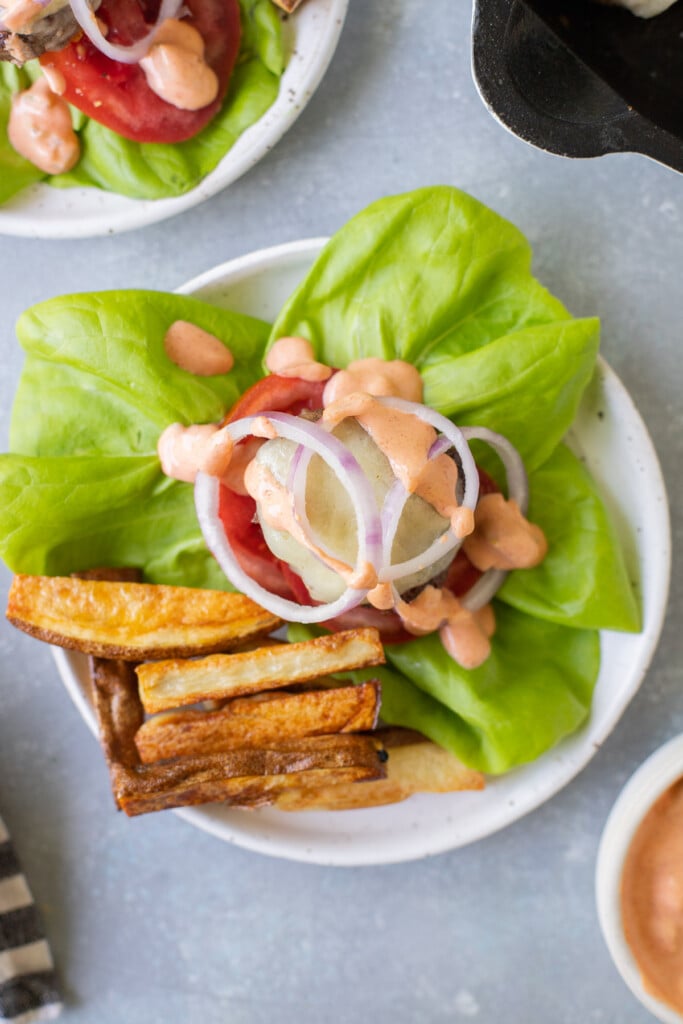 a close up of lettuce wrap burgers on a white dish
