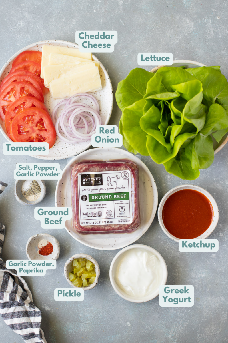 ingredients for lettuce wrap burgers in small white bowls on a grey background