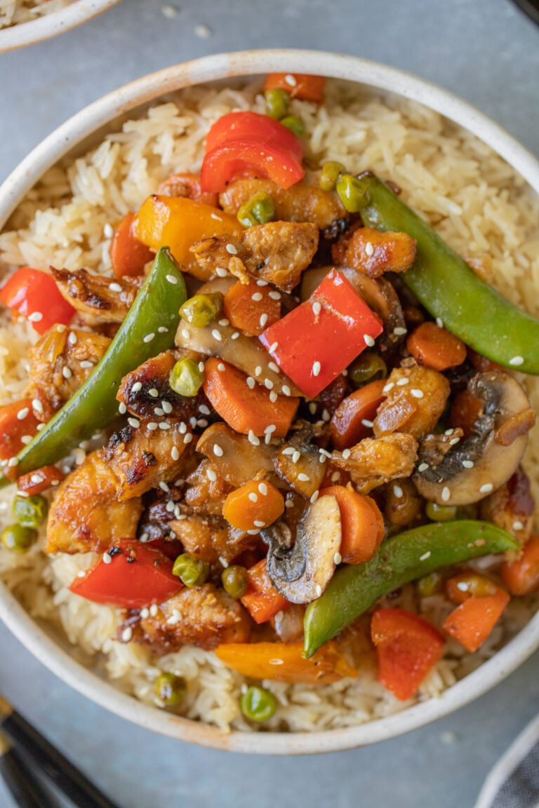 Chicken Stir Fry on a bed of rice in a bowl on a grey background