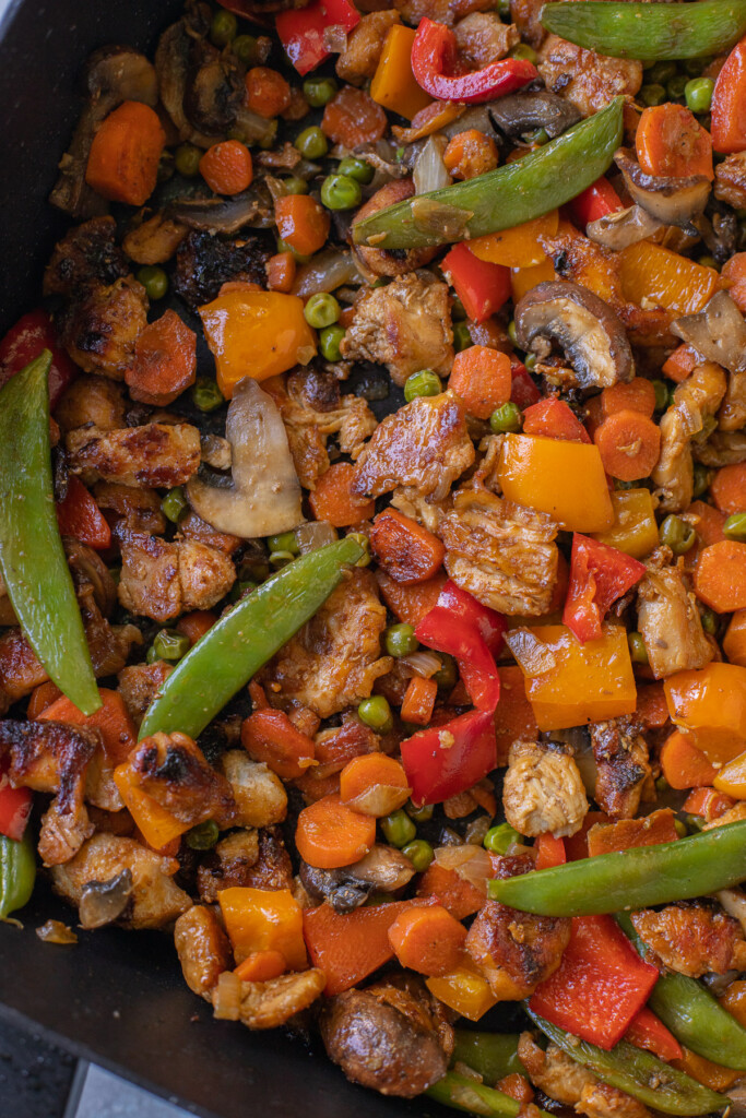 A close up of chicken stir fry that has a lot of veggies