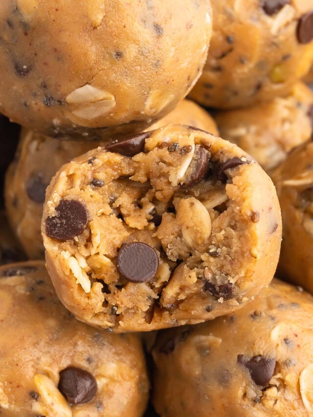 a peanut butter oatmeal ball with a bite taken out of it surrounded by more energy balls