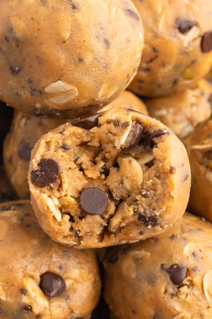 a peanut butter oatmeal ball with a bite taken out of it surrounded by more energy balls