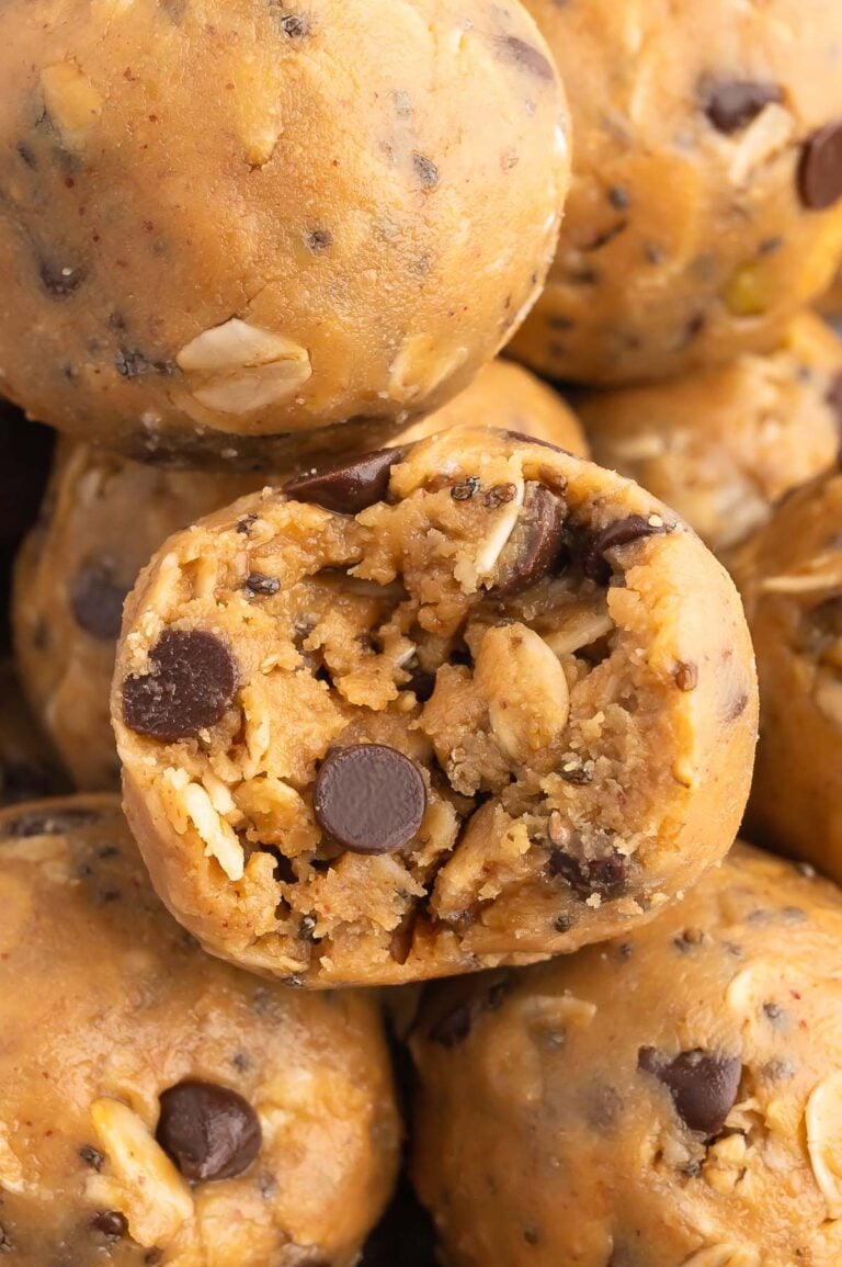 a peanut butter oatmeal ball with a bite taken out of it surrounded by more energy balls