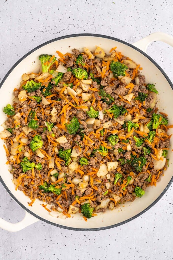Ground beef, onion, garlic, carrots, broccoli, and water chestnuts after cooking in a dutch oven for ground beef lettuce wraps
