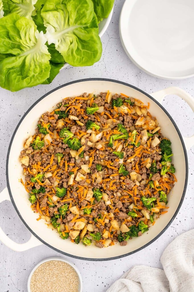 Ground beef lettuce wrap filling in a dutch oven with boston lettuce on the side