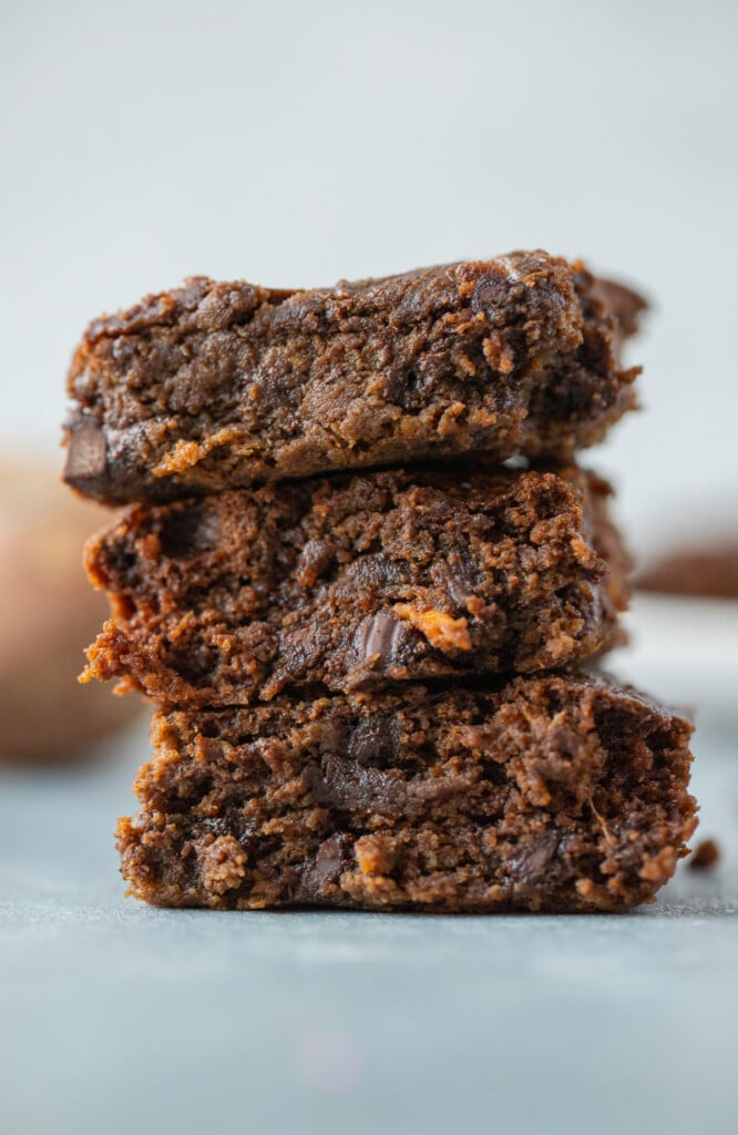 a stack of three sweet potato brownies on a blue counter