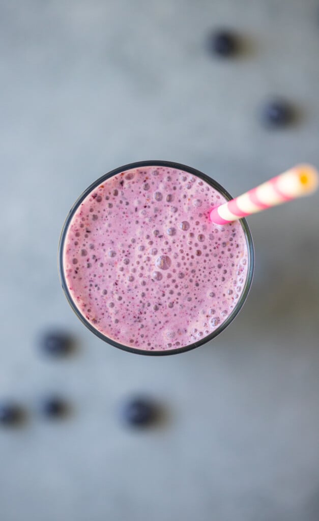 An overhead shot of fruit smoothie on a grey background