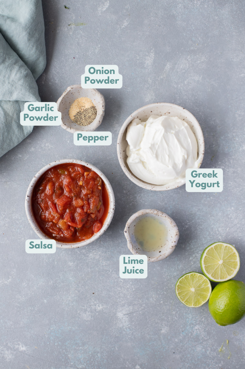 Ingredients for creamy taco dressing in small bowls: greek yogurt, salsa, garlic powder, onion powder, black pepper, lime juice