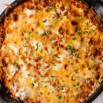 An overhead shot of unstuffed peppers skillet on a grey background