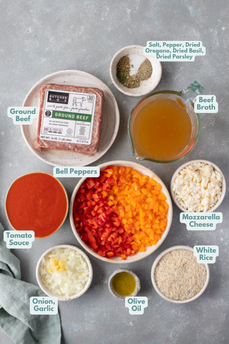 Ingredients for unstuffed peppers in small bowls: olive oil, ground beef, onion, garlic, pepper, dried oregano, dried basil, dried parsley, tomato sauce, dry white rice, beef broth, red bell pepper, mozzarella cheese