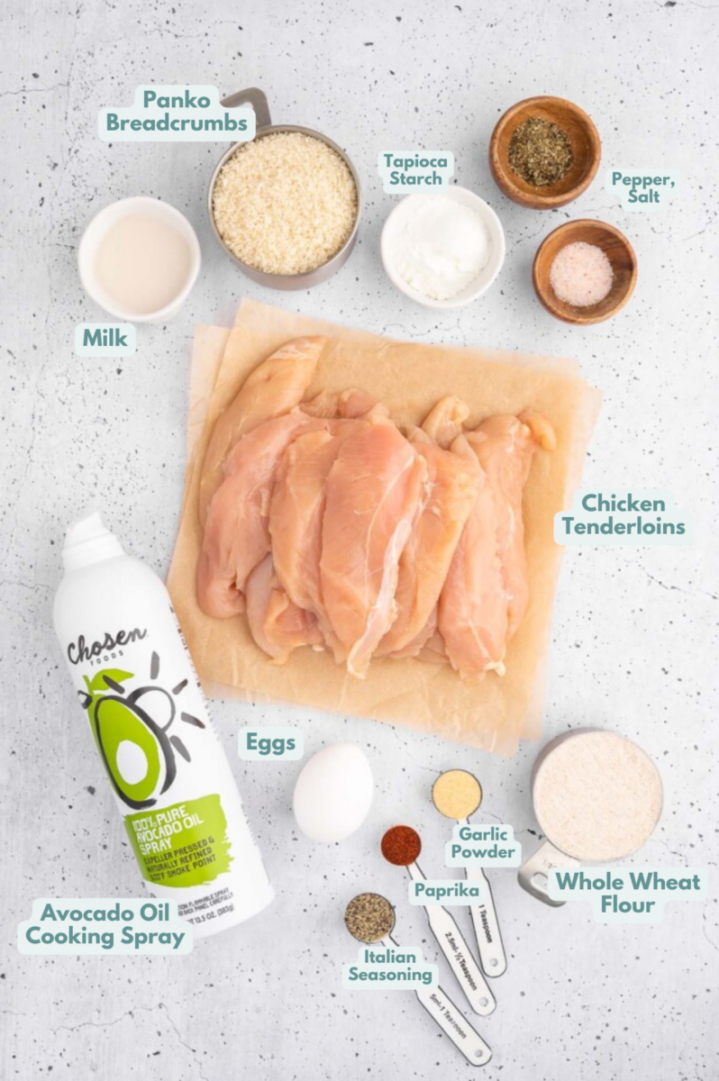 Ingredients for homemade chicken nuggets in small bowls: chicken tenderloins, egg, milk, tapioca starch, whole wheat all purpose flour, panko breadcrumbs, spices, cooking spray