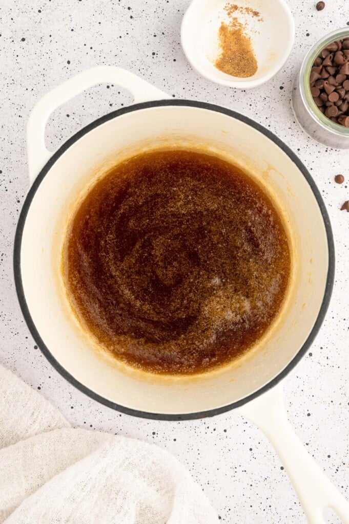 Coconut oil, coconut sugar, and honey in a sauce pan after cooking down into a syrup and vanilla extract added to make the binder for homemade granola bars