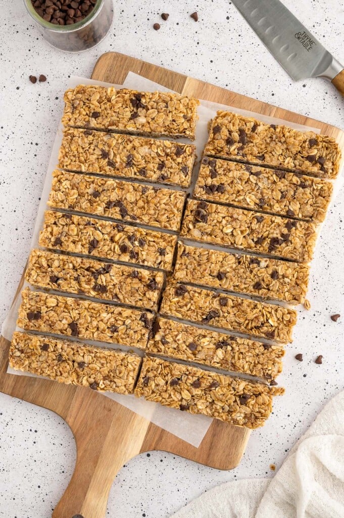 Sliced Healthy granola bars on a piece of parchment paper on a wooden cutting board