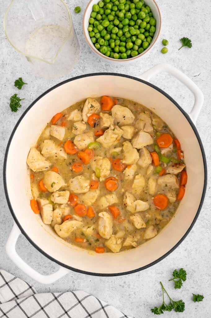 Crustless chicken pot pie filling in a dutch oven before being fully cooked and before frozen veggies and milk is added.