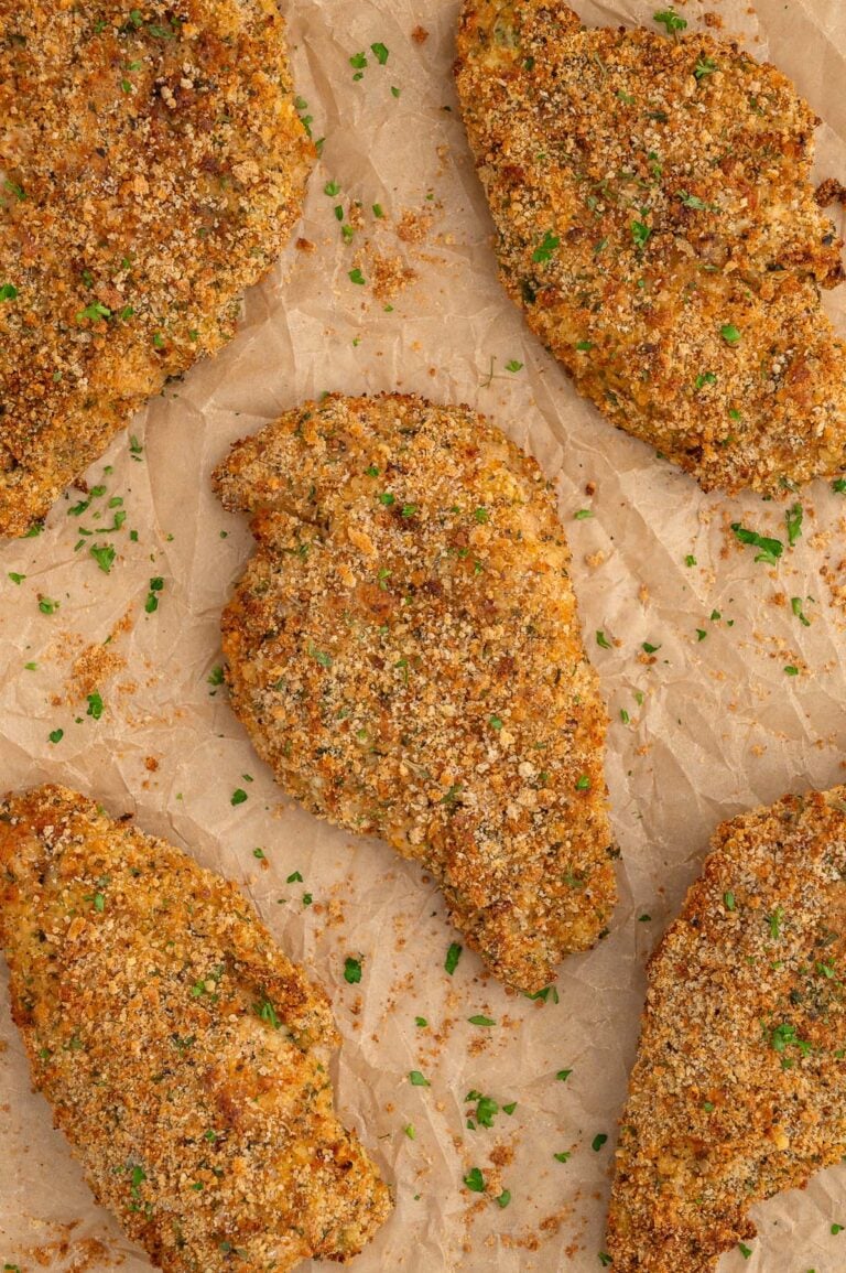 Baked chicken cutlets on a piece of parchment paper.