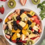 A large white bowl filled with a fruit salad.