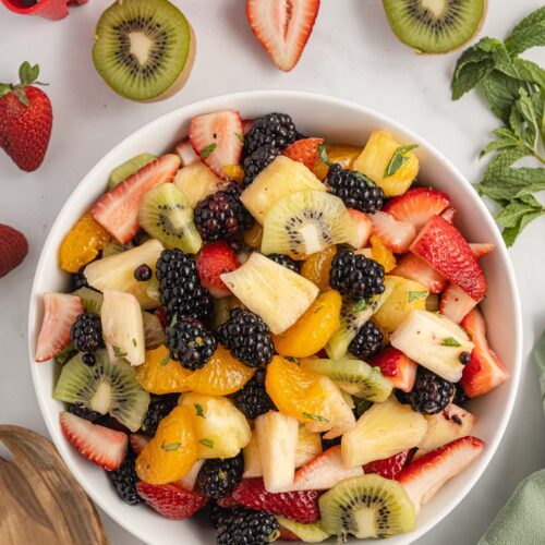 A large white bowl filled with a fruit salad.