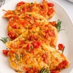 Chicken Scarpariello on a white platter on a white counter.