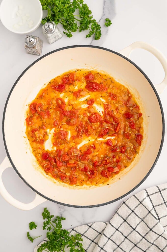 Chicken Scarpariello sauce in a dutch oven. 