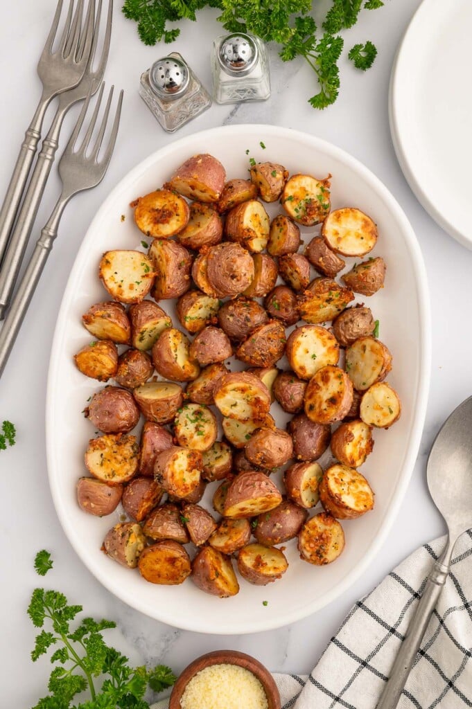 Garlic Roasted Potatoes on a white platter with forks on the side.