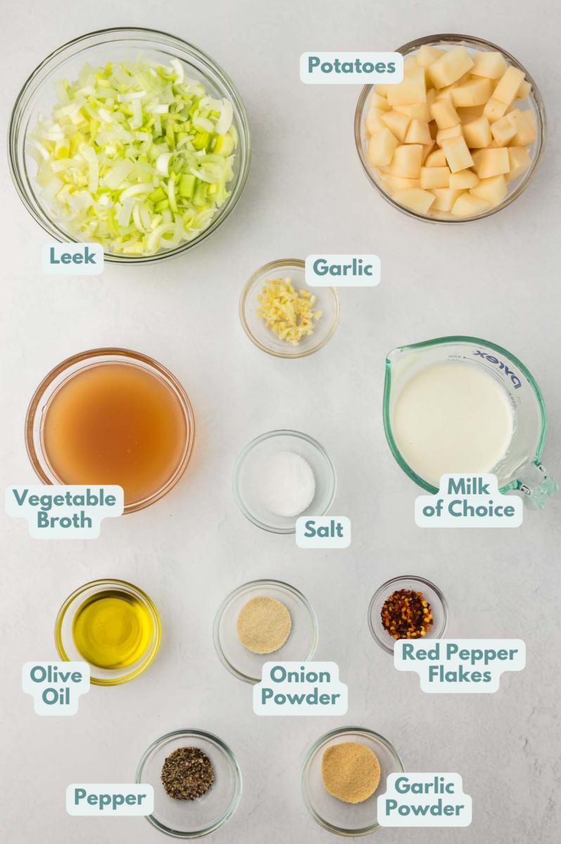 Ingredients for potato leek soup in bowls: olive oil, garlic, leeks, potatoes, vegetable broth, salt, pepper, onion powder, garlic powder, red pepper flakes, dried thyme, dried parsley, milk