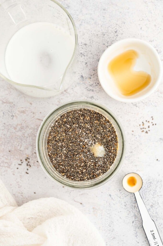 An overhead shot of all ingredients for chia seed pudding in a mason jar before mixing.