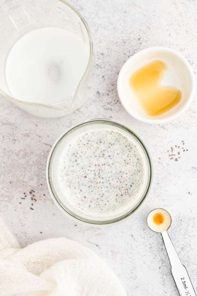 An overhead shot of all ingredients for chia seed pudding in a mason jar after shaking.