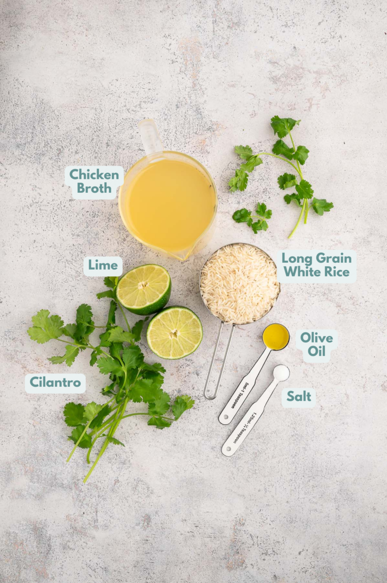 Ingredients for cilantro lime rice in small bowls: long grain white rice, chicken broth, salt, olive oil, cilantro, lime juice