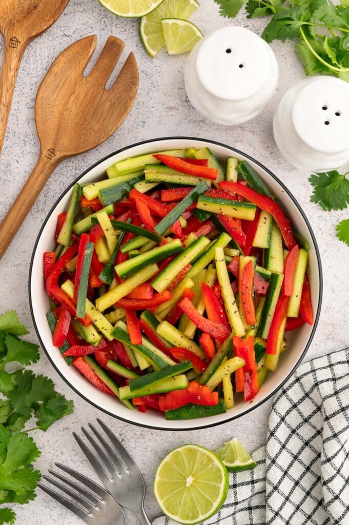 An overhead shot of marinated vegetable salad in a large bowl with a wooden spoon on the side. 