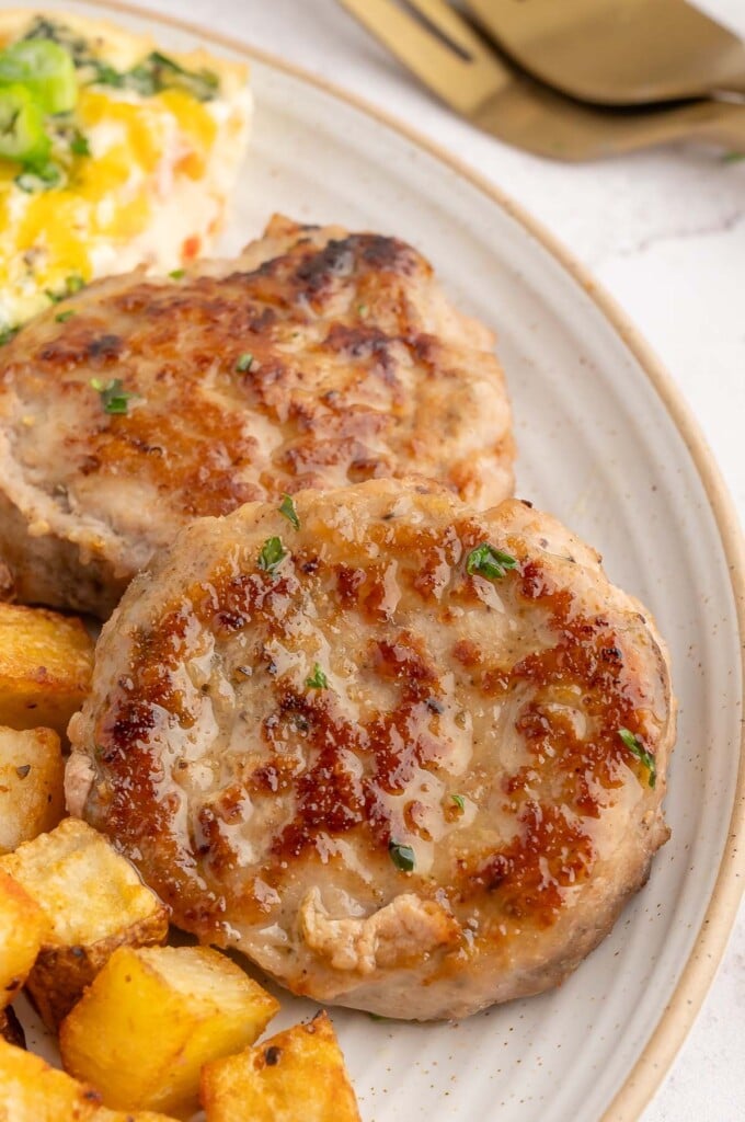 Two turkey breakfast sausage patties on a white plate.