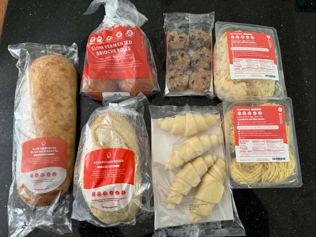 A close up of different breads and pastries from wildgrain - ciabatta, sourdough, rolls, croissants, cookies and pasta.