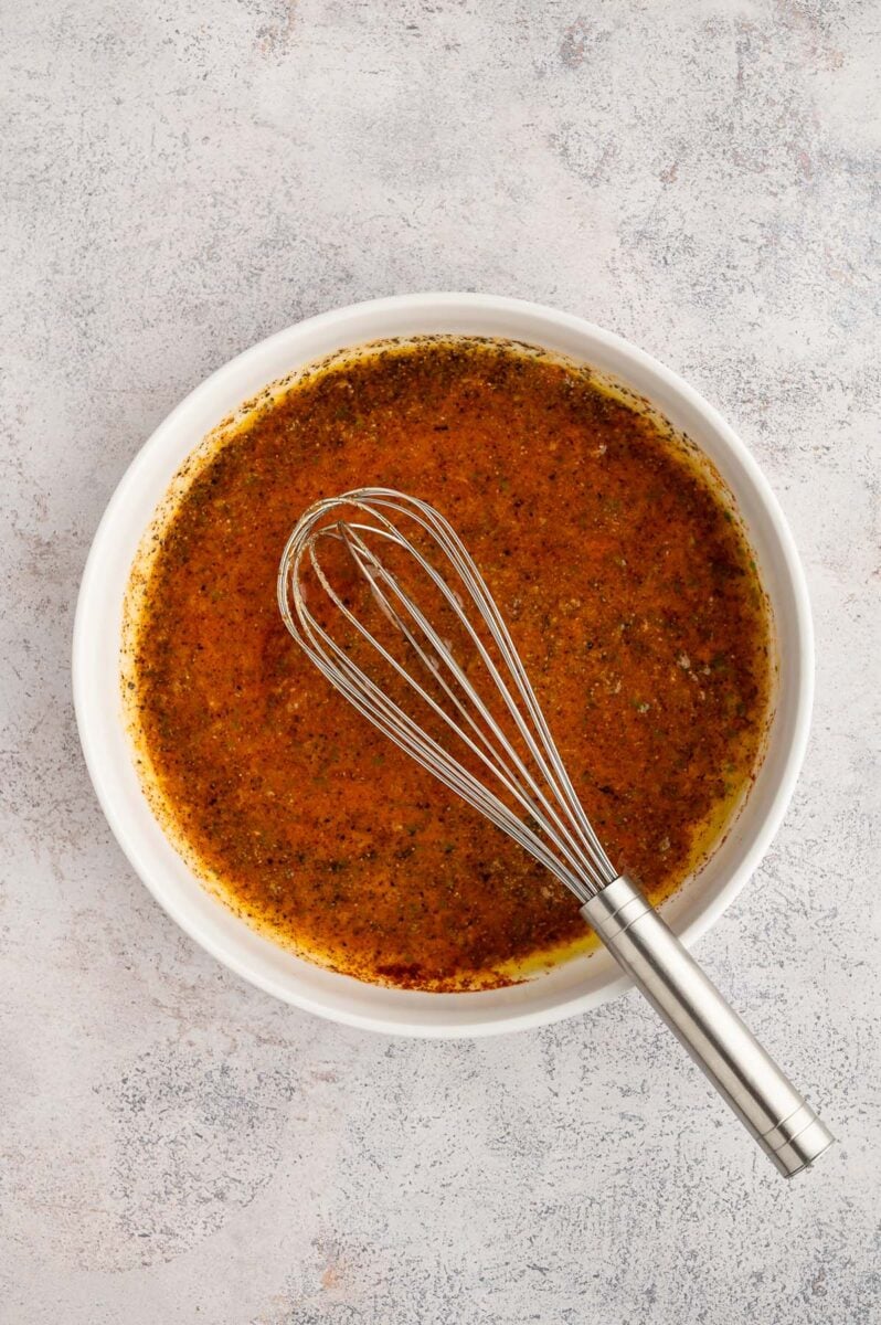 Chili Lime Marinade in a white bowl with a whisk in it.