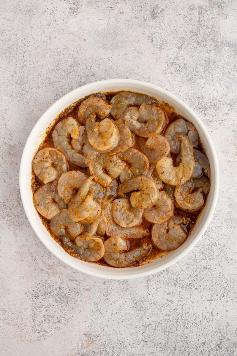 Raw Shrimp in a chili lime marinade in a white bowl.