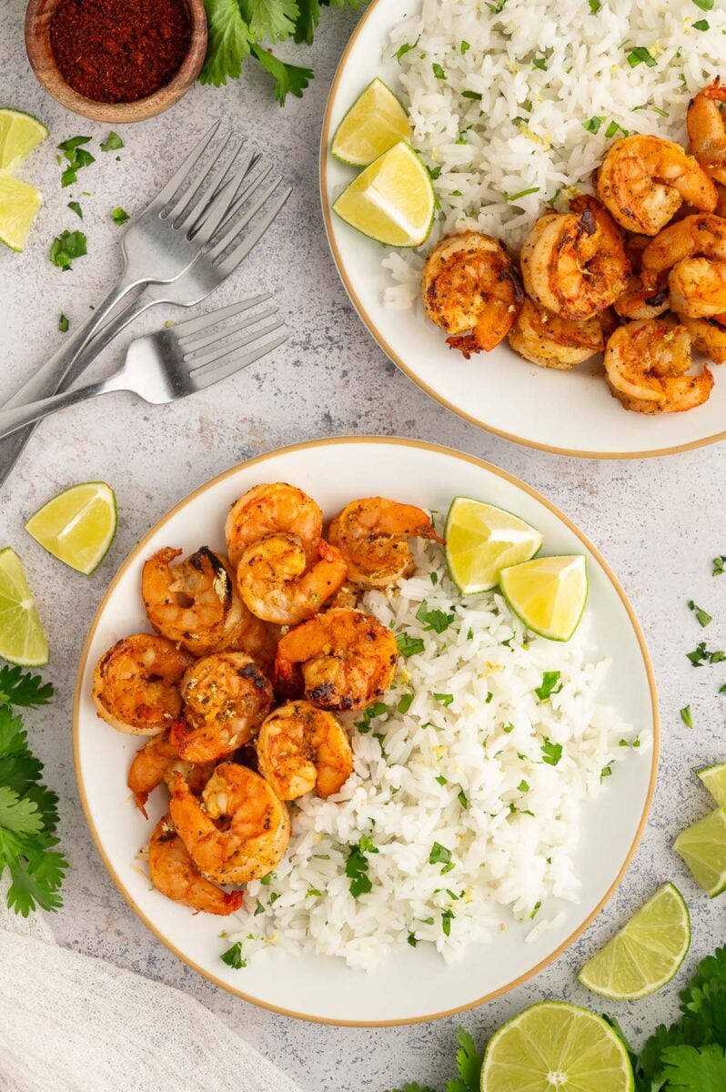 Chili Lime Shrimp and cilantro lime rice on a white plate with another plate on the side.