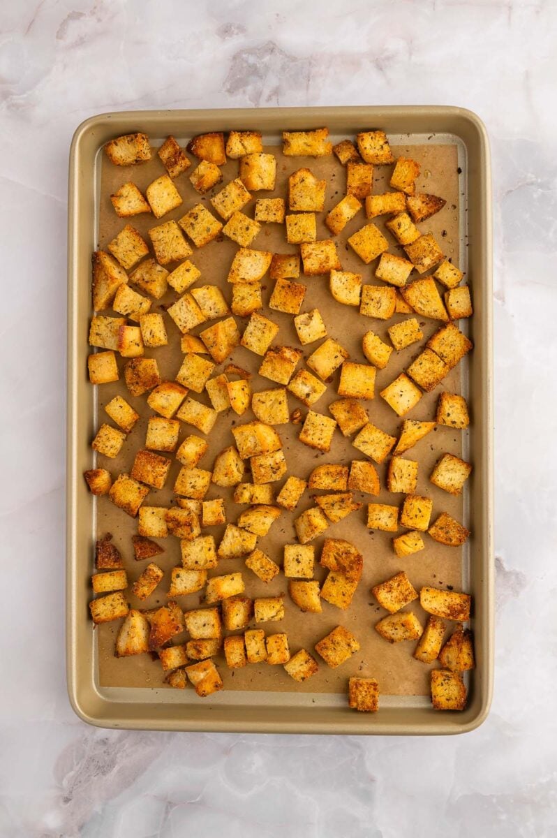 Homemade Croutons on a parchment lined baking sheet.