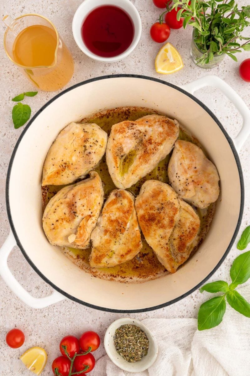 Chicken Breasts in a dutch oven that have been slightly browned.