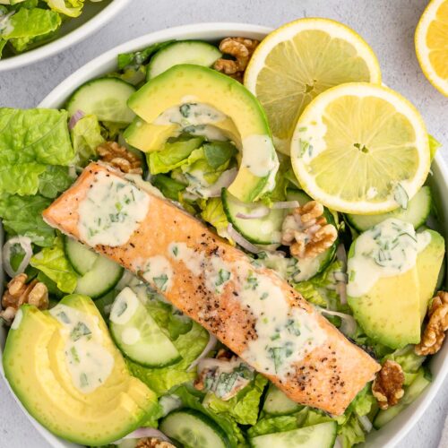 An overhead shot of a salmon salad topped with healthy tahini dressing.