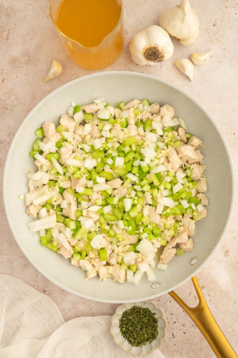 Chicken, onion, and celery cooking to make buffalo chicken and rice.