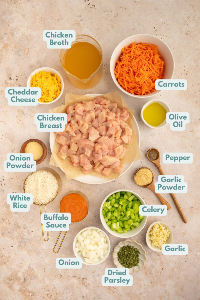 Ingredients for buffalo chicken and rice in small bowls on a counter, labeled. 