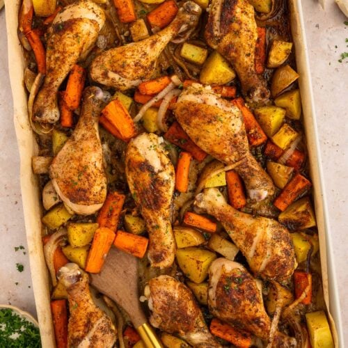 An overhead shot of sheet pan drumsticks, carrots, and potatoes.