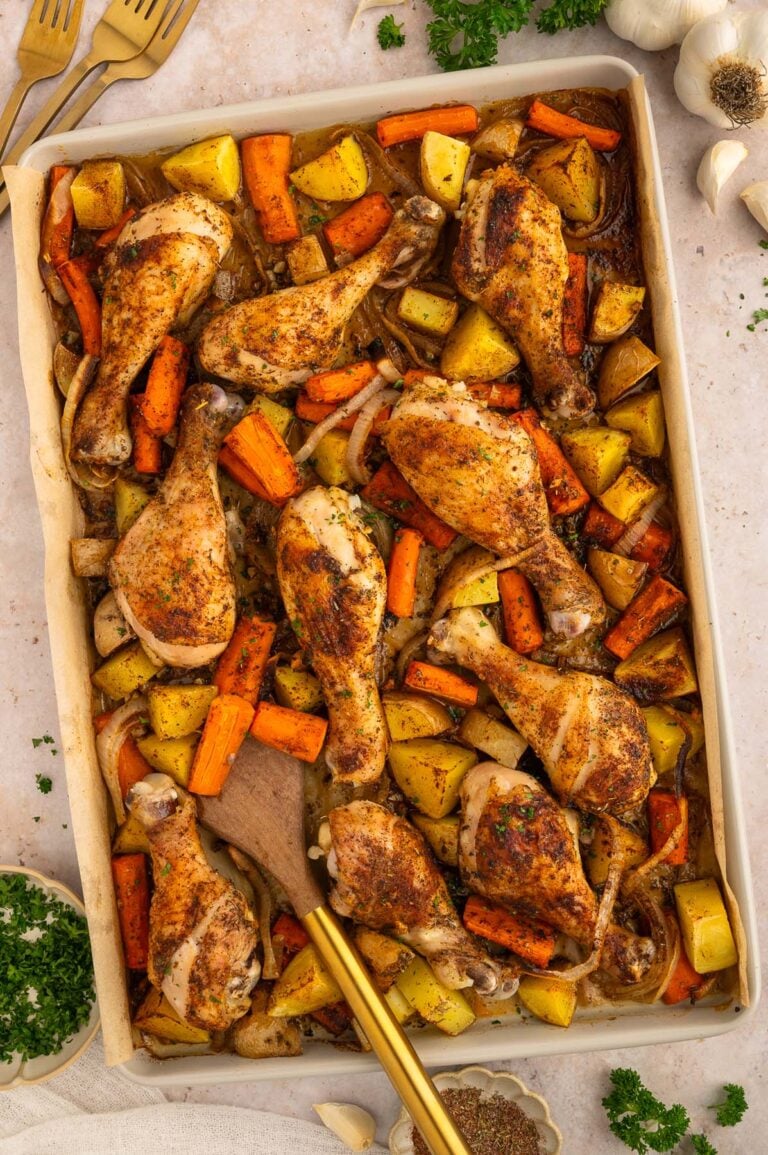 An overhead shot of sheet pan drumsticks, carrots, and potatoes.