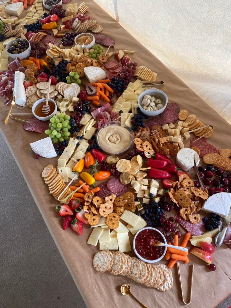 Charcuterie board with los of cheese, fruits and veggies
