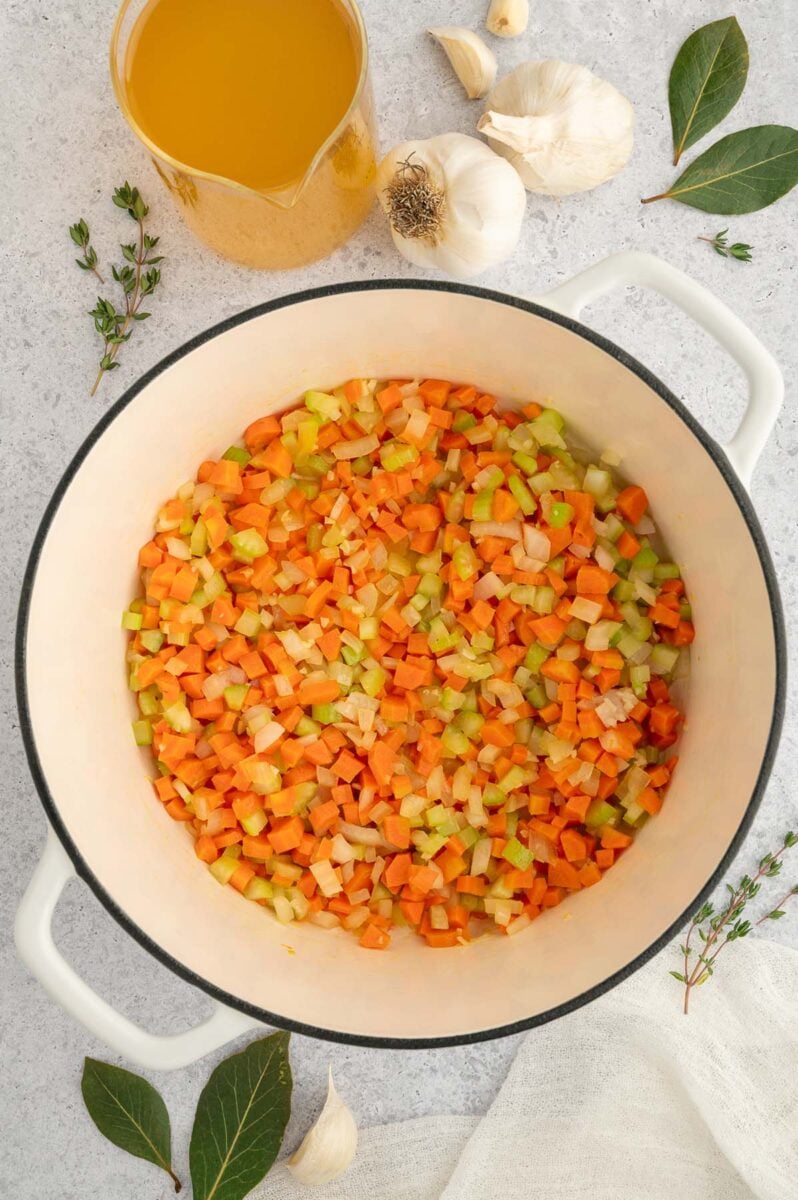 Carrots, celery, onions cooking in a dutch oven.
